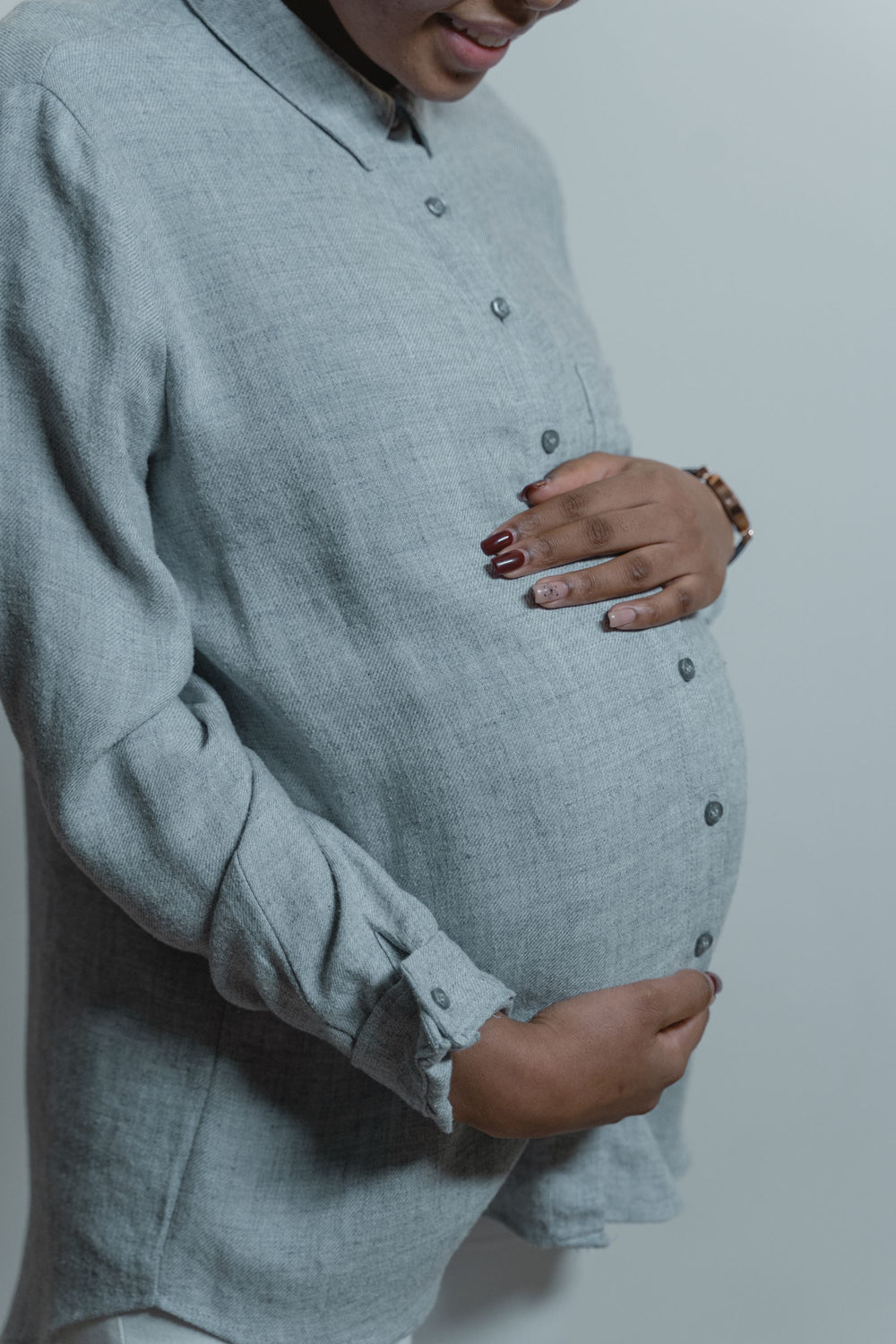 Femme enceinte, les mains posées sur son ventre - Petit Murmure