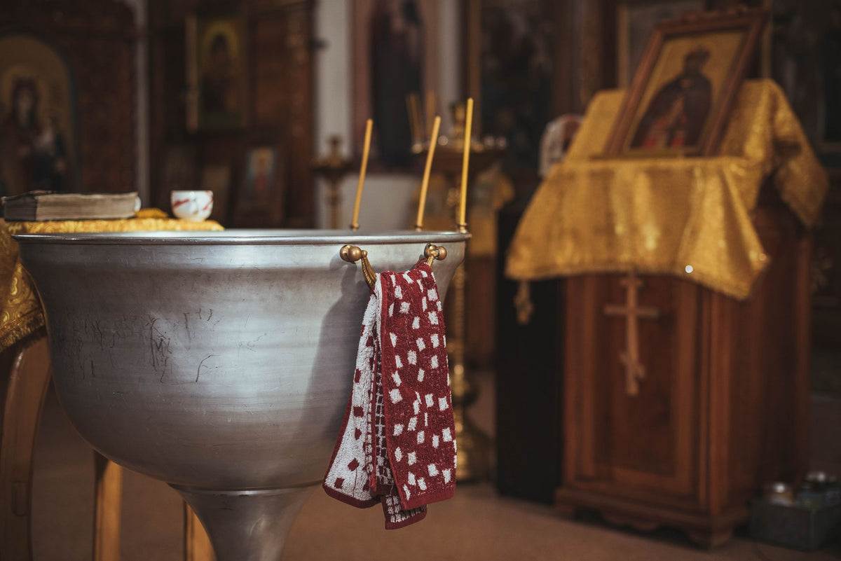 Fonts baptismaux et cierge allumé dans une église - baptême catholique | Petit Murmure