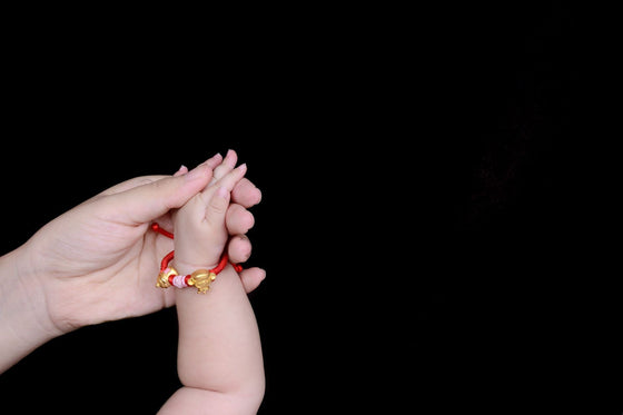 Bijou pour jeune maman porté au poignet avec un nouveau-né | Petit Murmure