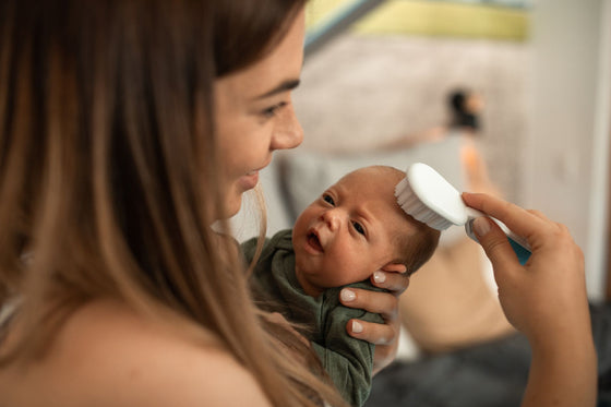 Maman coiffant les cheveux d'un nouveau-né avec une brosse douce - brosse pour bébé | Petit Murmure