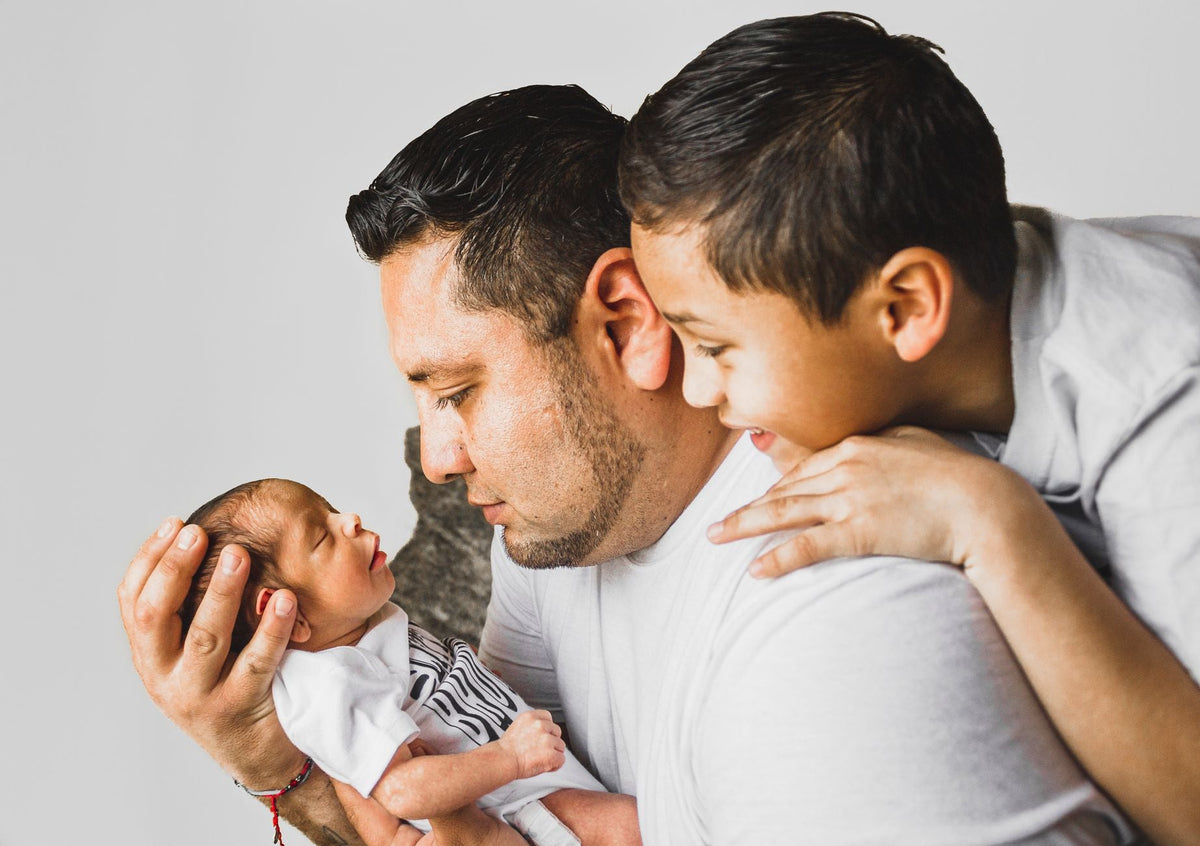 Nouveau-né et son aîné dans les bras des parents - cadeau naissance deuxième enfant | Petit Murmure