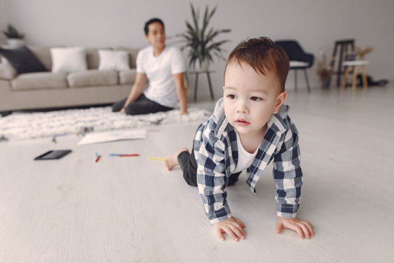 Bébé à quatre pattes explorant le salon de la maison - sécuriser sa maison pour bébé | Petit Murmure