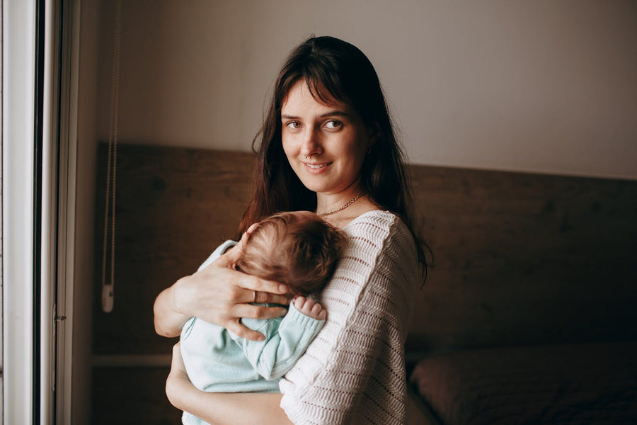 Une maman tient son nouveau-né contre elle - Petit Murmure